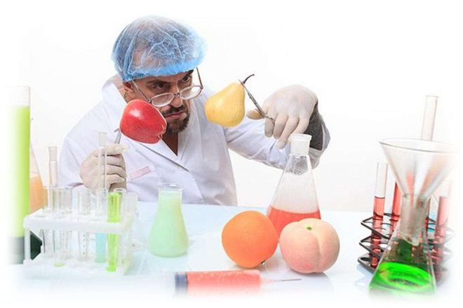 ученый, фрукты и колбы с жидкостью на столе
