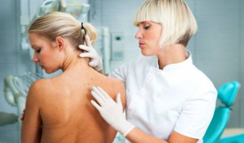 Дерматолог осматривает кожу пациентки