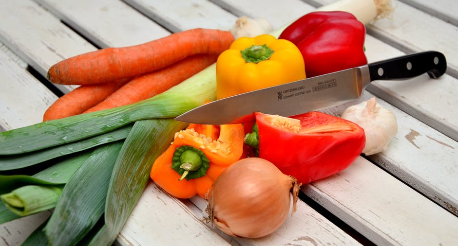 кухонный нож лежит в груде овощей