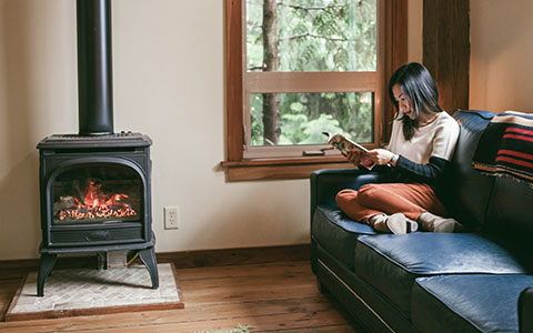 Woman sitting by pellet stove